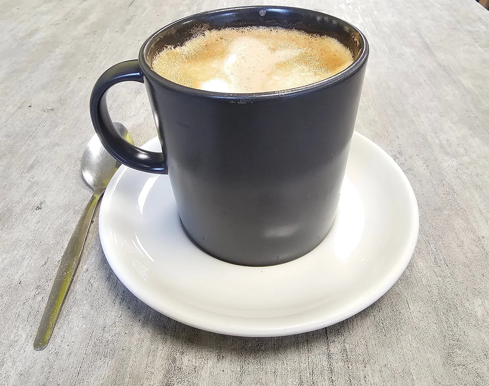 A mug of coffee on a saucer at Cowplain Cafe